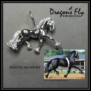 May include: Silver charm of a black Friesian horse with a long mane and tail, in a rearing pose. The charm is labeled "Mintse 384 Sport". A photo of a black Friesian horse in a field is shown below the charm.