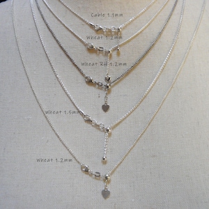 May include: Five silver chains of different styles and lengths, including cable and wheat chains, with heart-shaped charms at the ends. The chains are labelled with their names and sizes in millimetres.
