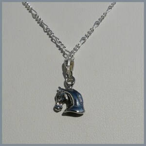 May include: A silver chain necklace with a silver horse head pendant.