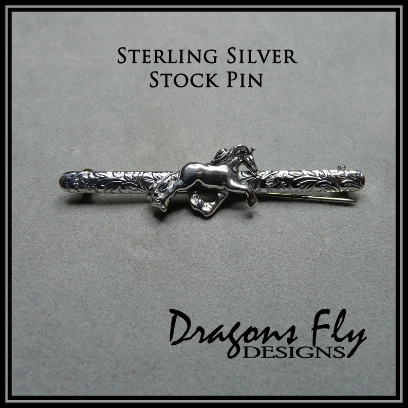 May include: Sterling silver stock pin featuring a detailed design of a horse running through a floral pattern. The pin is made by Dragons Fly Designs.