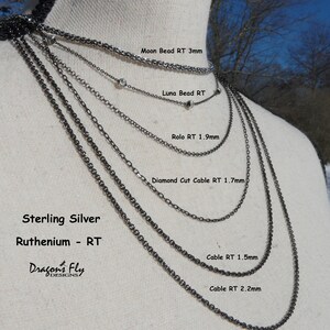 K&ouml;nnte beinhalten: Nahaufnahme eines Mannequins, das neun verschiedene Sterling-Silberketten mit Ruthenium-Finish tr&auml;gt. Die Ketten sind mit ihren Namen und Gr&ouml;&szlig;en in Millimetern beschriftet. Die Ketten sind nach Gr&ouml;&szlig;e geordnet, wobei die kleinste Kette oben und die gr&ouml;&szlig;te Kette unten liegt. Die Ketten sind alle aus Sterling-Silber gefertigt und haben ein Ruthenium-Finish. Die Ketten sind alle in verschiedenen L&auml;ngen erh&auml;ltlich.