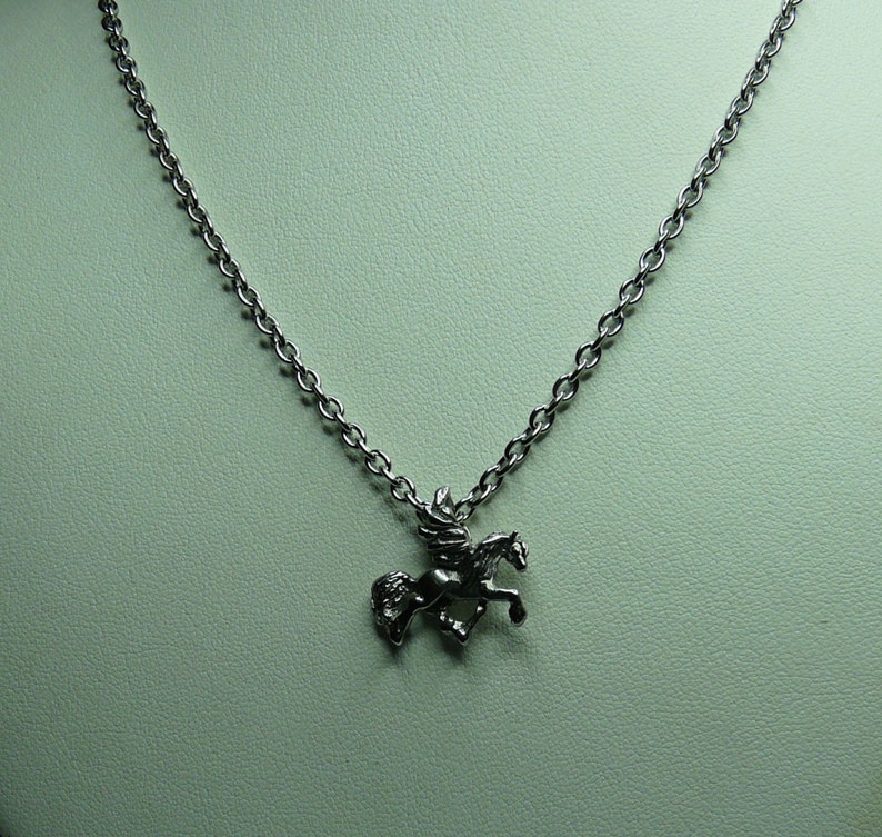 May include: A silver chain necklace with a pendant of a winged horse, or pegasus, in flight.