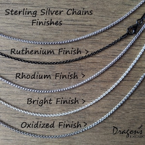 May include: Five sterling silver chains in different finishes: oxidised, bright, rhodium, ruthenium, and black. The chains are laid out on a wooden surface. Sterling Silver Chains Finishes Ruthenium Finish > Rhodium Finish > Bright Finish > Oxidised Finish > Dragon's Fly DESIGNS