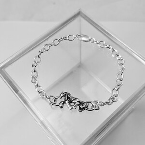 May include: A silver chain bracelet featuring a horse charm. The bracelet is made from a delicate chain and the horse charm is detailed and realistic.