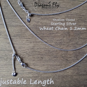 K&ouml;nnte beinhalten: Nahaufnahme von drei Halsketten mit Weizenketten aus Sterlingsilber mit verstellbaren L&auml;ngen. Die Ketten sind 1,2 mm dick und rhodiniert. Der Text "Adjustable Length" befindet sich am unteren Rand des Bildes.