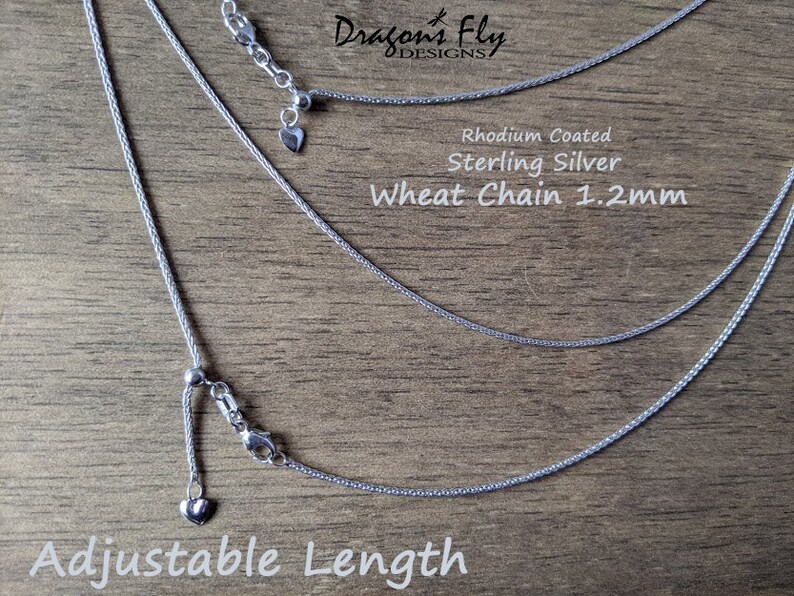 K&ouml;nnte beinhalten: Nahaufnahme von drei Halsketten mit Weizenketten aus Sterlingsilber mit verstellbaren L&auml;ngen. Die Ketten sind 1,2 mm dick und rhodiniert. Der Text "Adjustable Length" befindet sich am unteren Rand des Bildes.