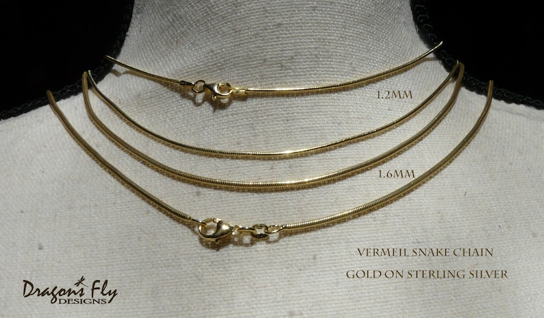 May include: Three gold vermeil snake chains on a white background. The chains are 1.2mm, 1.6mm, and 2mm wide. VERMEIL SNAKE CHAIN GOLD ON STERLING SILVER.