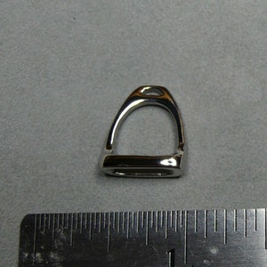 May include: A silver stirrup charm pendant. The charm is about 1 inch in length.