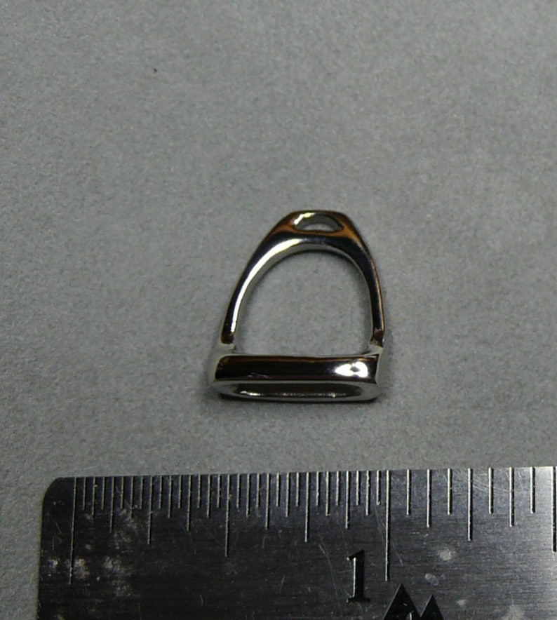 May include: A silver stirrup charm pendant. The charm is about 1 inch in length.