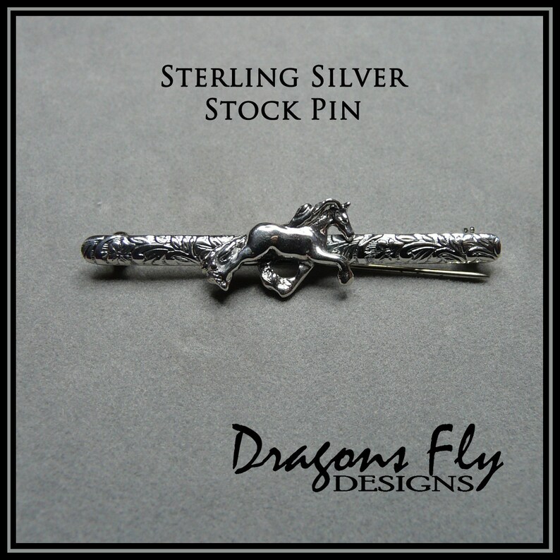 May include: Sterling silver stock pin featuring a detailed design of a horse running through a floral pattern. The pin is made by Dragons Fly Designs.