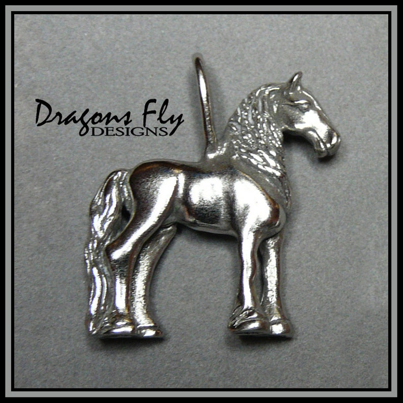 May include: Silver horse charm pendant with a detailed design. The charm is standing on all four legs with its head turned to the side. The charm is made by Dragons Fly Designs.