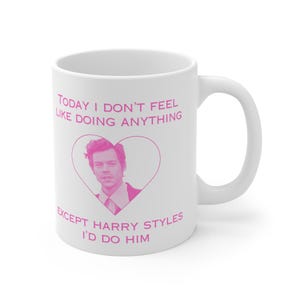 May include: White ceramic mug with a pink heart and a picture of Harry Styles. The text reads "Today I don't feel like doing anything except Harry Styles I'd do him."