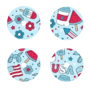 May include: Four round stickers with a blue background and red, white, and blue patriotic designs. The designs include fireworks, ice cream cones, watermelon slices, and the word "USA".