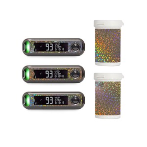 May include: Three black and silver blood glucose monitors with a green light and a digital display showing "93 mg/dL 2:28AM 8/8/18". Two small, white, round containers with a holographic, iridescent, glittery design.