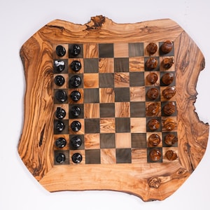 May include: A handcrafted wooden chess set with a live edge border. The chessboard features a checkerboard pattern with dark and light squares. Black and brown chess pieces are arranged on the board, ready for play.