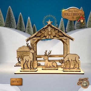 May include: A wooden Christmas nativity scene with three deer, a shelter, and a wagon. The scene is set against a snowy backdrop with evergreen trees and the text "Step Into HOLLYBROOK". A "DIY KIT" label is in the lower left.