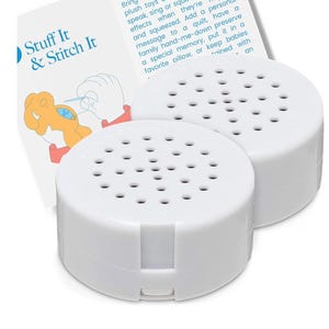 May include: Two white, circular plastic sound recording devices with perforated speaker grilles on top. Behind the devices is a white instructional card featuring the text Stuff It & Stitch It and an illustration of a hand sewing a plush toy.