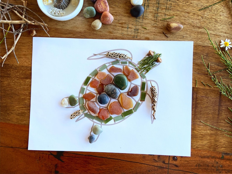 May include: A turtle made out of small stones and twigs on a white background. The turtle's shell is made of orange, brown, green, and blue stones. The turtle's head and legs are made of twigs.