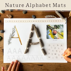Può includere: Un tappetino alfabetico a tema natura con il testo "Nature Alphabet Mats". La lettera "A" è mostrata in tre stili diversi, tra cui uno realizzato con materiali naturali. Sono inclusi anche un'immagine di ghianda e un cruciverba.