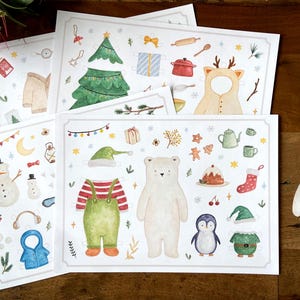 May include: Watercolour illustrations of Christmas-themed paper dolls and accessories. Includes a snowman, polar bear, penguin, Christmas tree, and various outfits and decorations. Ideal for holiday crafts and decor.