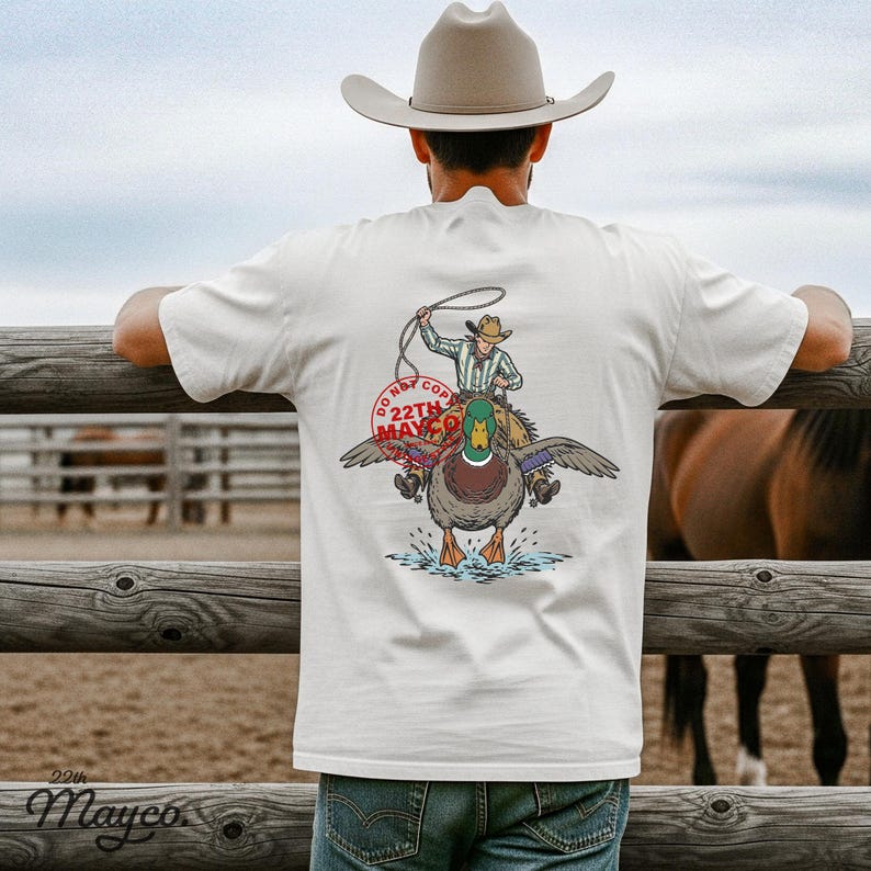 sublimation design for duck hunter shirts, high quality transparent duck png, dtf transfer cowboy riding duck, printable vinyl mallard duck sticker, digital asset for western brand, commercial use duck hunting graphic, print on demand outdoor apparel, diy rustic lodge sign project, easy weed vector style duck, customized duck lover gift template, mallard duck png for sublimation, high resolution duck hunter gear, lake life sublimation transfer, western animal shirt design, duck dgt asset