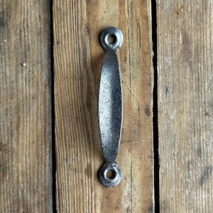 May include: A black metal door handle with a rounded oval shape and a slightly textured finish.