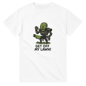 May include: White t-shirt featuring a cartoon illustration of a green-skinned robot-like figure holding a green weapon. The text "GET OFF MY LAWN!" is printed below the figure in black letters.