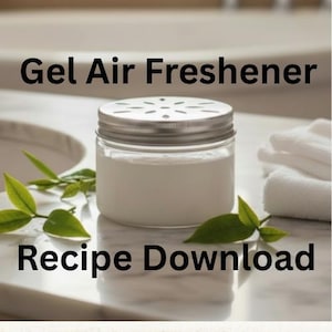 Könnte beinhalten: Ein klares Glas mit silbernem Deckel, gefüllt mit weißem Gel-Lufterfrischer. Das Glas steht auf einer Marmoroberfläche, mit grünen Blättern und dem Text "Gel Air Freshener Recipe Download". Weiße Handtücher sind im Hintergrund.