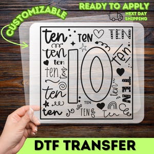May include: A black and white DTF transfer with the number 10 and the word "ten" in various fonts and designs. The transfer includes hearts, stars, and a rainbow. The words "Customizable" and "Ready to Apply" are also present.