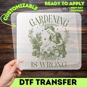 May include: A clear DTF transfer with a vintage-style illustration in green. The design features a woman gardening with the text "Gardening Because Murder Is Wrong." The transfer is labeled "Customizable" and "Ready to Apply."