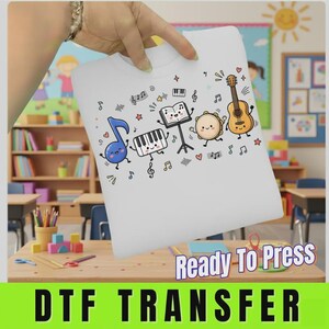 May include: A white heat transfer sheet featuring a colorful cartoon graphic of musical instruments and notes, including a blue musical note, a piano keyboard, a music stand with an open book, a tambourine, and an acoustic guitar with faces.