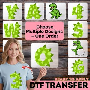 May include: The image showcases a variety of green dinosaur-themed DTF transfers, including letters, numbers, and dinosaur illustrations. The text "Choose Multiple Designs - One Order" is displayed, along with "READY TO APPLY DTF TRANSFER". A woman is wearing a light blue t-shirt with a number 3 transfer.