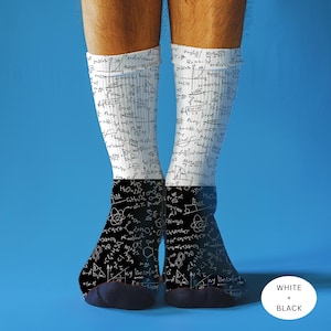 May include: White and black socks with a science theme. The socks feature mathematical formulas and diagrams printed on them. The lower portion of the socks is black, while the upper portion is white.
