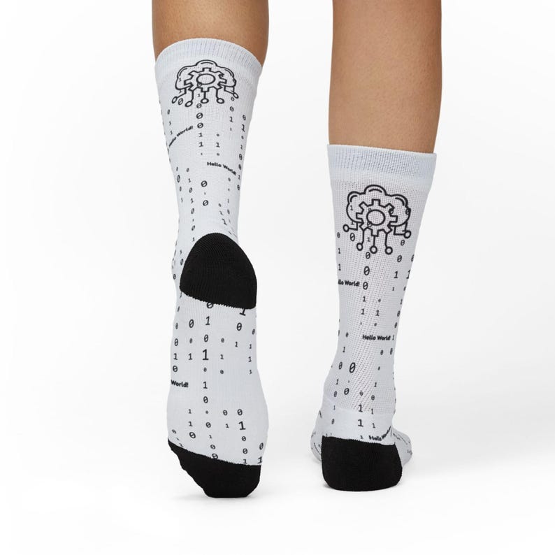 May include: White socks with black heels and toes, featuring a cloud and gear graphic. The socks are decorated with binary code and the text "Hello World!" in black.