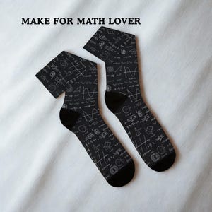 May include: A pair of black socks patterned with white mathematical formulas and diagrams. The socks have black heels and toes. The text "MAKE FOR MATH LOVER" is at the top of the image.