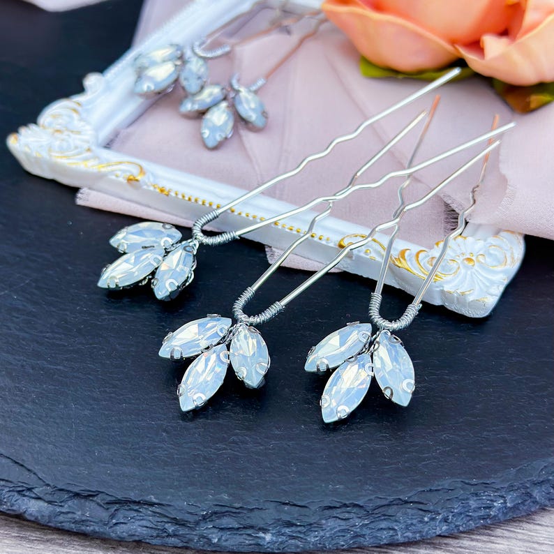 Elegant blue opal hair pin in silver, featuring sparkling opal and clear crystals with deep blue and green rhinestones, set in a sleek silver alloy frame.