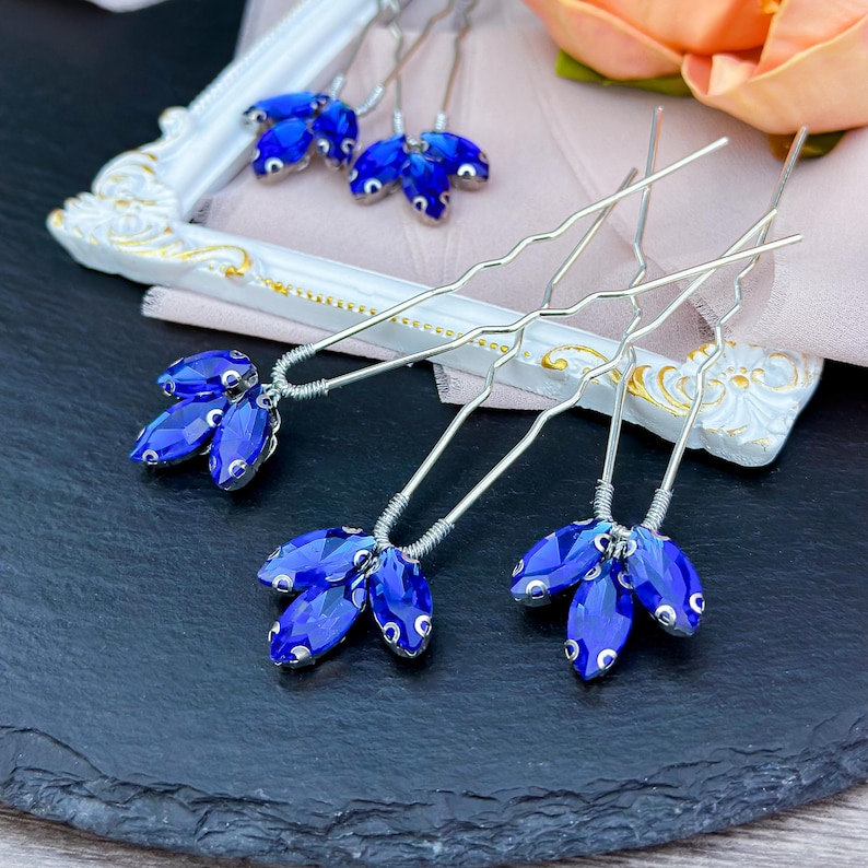 Elegant blue crystal hair pin in silver, featuring radiant deep blue crystals set in a sleek silver alloy frame, perfect for adding a touch of color and sparkle to bridal or formal hairstyles.