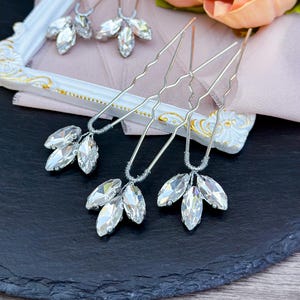 Elegant clear crystal hair pin in silver, featuring sparkling clear crystals arranged in a delicate design, set in a sleek silver alloy frame, perfect for a bridal or formal hairstyle.