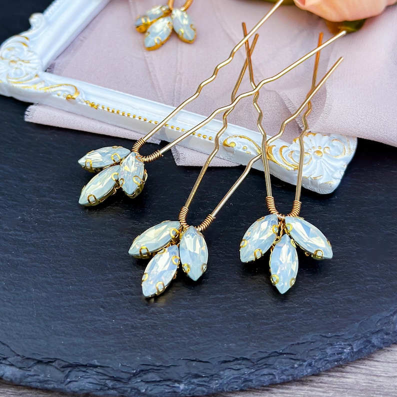 Stunning blue opal hair pin in gold, adorned with shimmering opal and clear crystals along with deep blue and green rhinestones, set in a luxurious gold alloy.