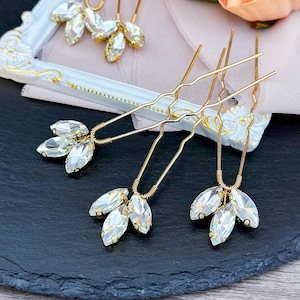 Stunning clear crystal hair pin in gold, adorned with shimmering clear crystals in a refined design, set in a luxurious gold alloy, adding a touch of glamour to any updo or formal hairstyle.