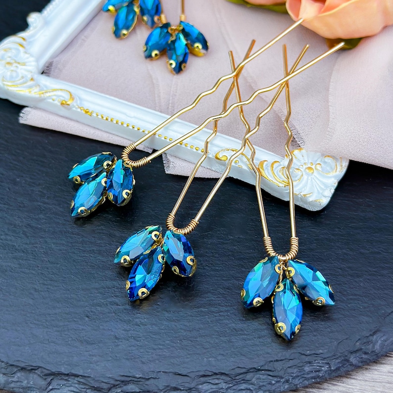 Stunning blue crystal hair pin in gold, adorned with vibrant deep blue crystals set in a luxurious gold alloy, ideal for enhancing updos and formal hairstyles with a chic pop of color.