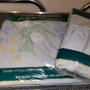 May include: A package of a double fitted sheet in a light blue color with a floral pattern. The package is labeled "Springmaid No-Iron Tranquility" and includes the fabric composition: "80% Kodel® Polyester 20% Cotton".