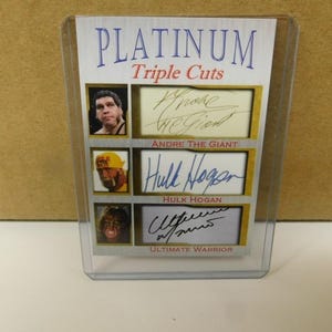 Puede incluir: Una tarjeta de intercambio Platinum Triple Cuts con firmas autografiadas de André el Gigante, Hulk Hogan y Ultimate Warrior. La tarjeta presenta una foto de cada luchador.