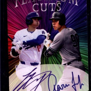 May include: A baseball card featuring two baseball players in their uniforms. The card has a rainbow background with the text "PLATINUM CUTS" at the top. The players' signatures are visible in the bottom right corner of the card.