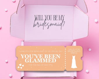 Może przedstawiać: Jasnoróżowe pudełko prezentowe z napisem "WILL YOU BE MY bridesmaid?" w środku. Brzoskwiniowy bilet z napisem "YOU'VE BEEN GLAMMED" i grafiką sukienki znajduje się w pudełku. Tło jest jasnoróżowe z białymi kulami.