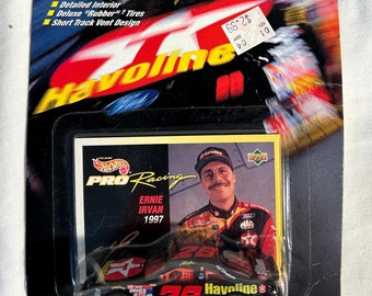 May include: A black and red die-cast toy car with the number 28 on the side. The car is a replica of Ernie Irvan's 1997 Havoline race car. The car is packaged in a plastic blister pack with a cardboard backing. The packaging features the Hot Wheels logo and the words "Pro Racing".