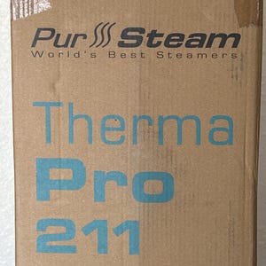 May include: A cardboard box with the text "Pur Steam World's Best Steamers" in black and "Therma Pro 211" in blue. The box is sealed with clear tape.