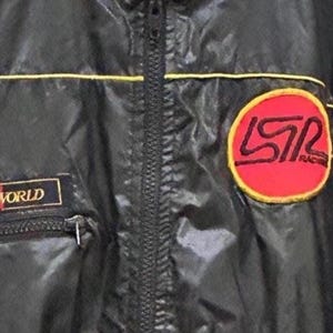 May include: Black nylon jacket with a full zipper, yellow trim, and a red and yellow patch that says "LSR Racing". The jacket also has a "Sports World" patch.