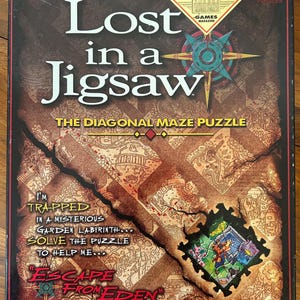 Puede incluir: Caja de rompecabezas titulada "Lost in a Jigsaw". La caja presenta un fondo marrón y beige con un diseño tipo mapa y las palabras "Escape From Eden". También presenta un premio "Best Puzzle of the Year".