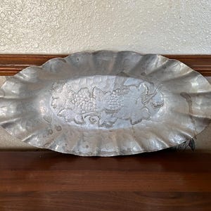 May include: A white ceramic mug with a black handle and the text "But First, Coffee" in a black, bold font. The mug is sitting on a white surface. The mug is approximately 4 inches tall.